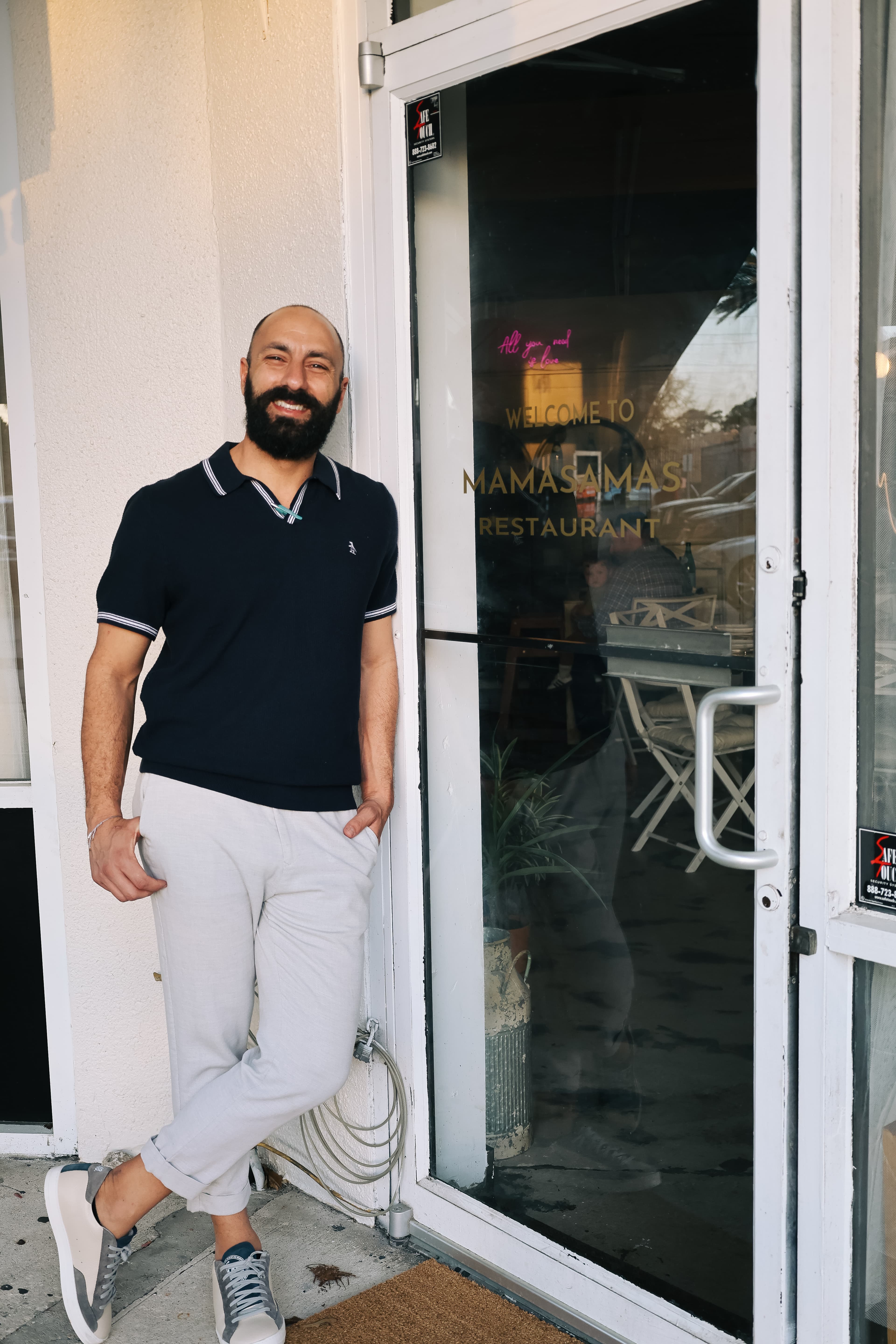Nic, owner of Mamasamas, standing at the restaurant entrance